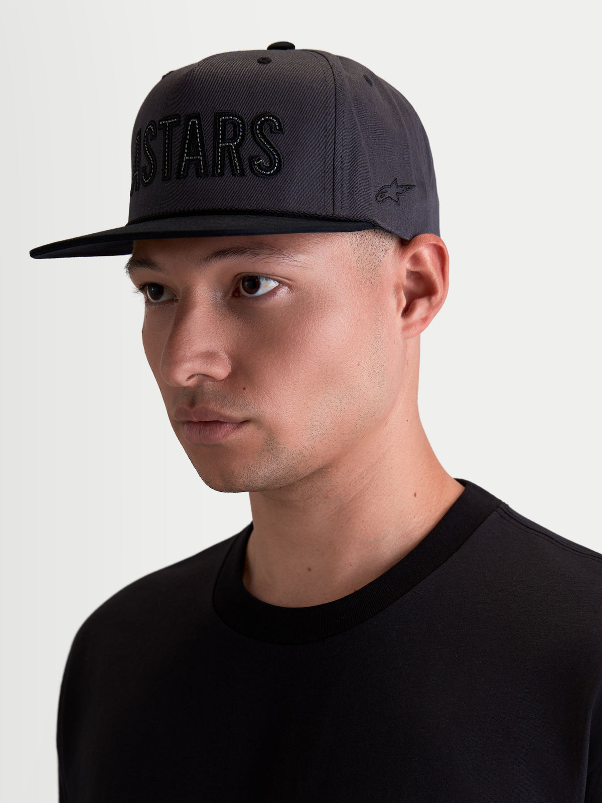 Alpinestars Gorra Stadium Snapback, gorra de estilo motorsport para hombre, gris oscuro y negro, corona estructurada con visera plana, aplique frontal ASTARS y bordado lateral, tejido de sarga de algodón, vista en modelo