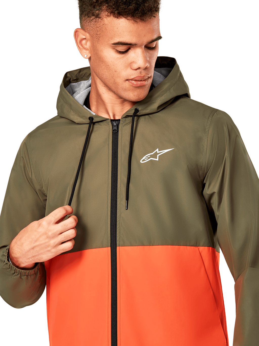Alpinestars Speeder Windbreaker Jacket, chaqueta cortavientos ligera con capucha, diseño bicolor en verde oliva y naranja militar, logotipo de Alpinestars blanco en el pecho, cremallera y cordones negros, ropa deportiva casual inspirada en el automovilismo