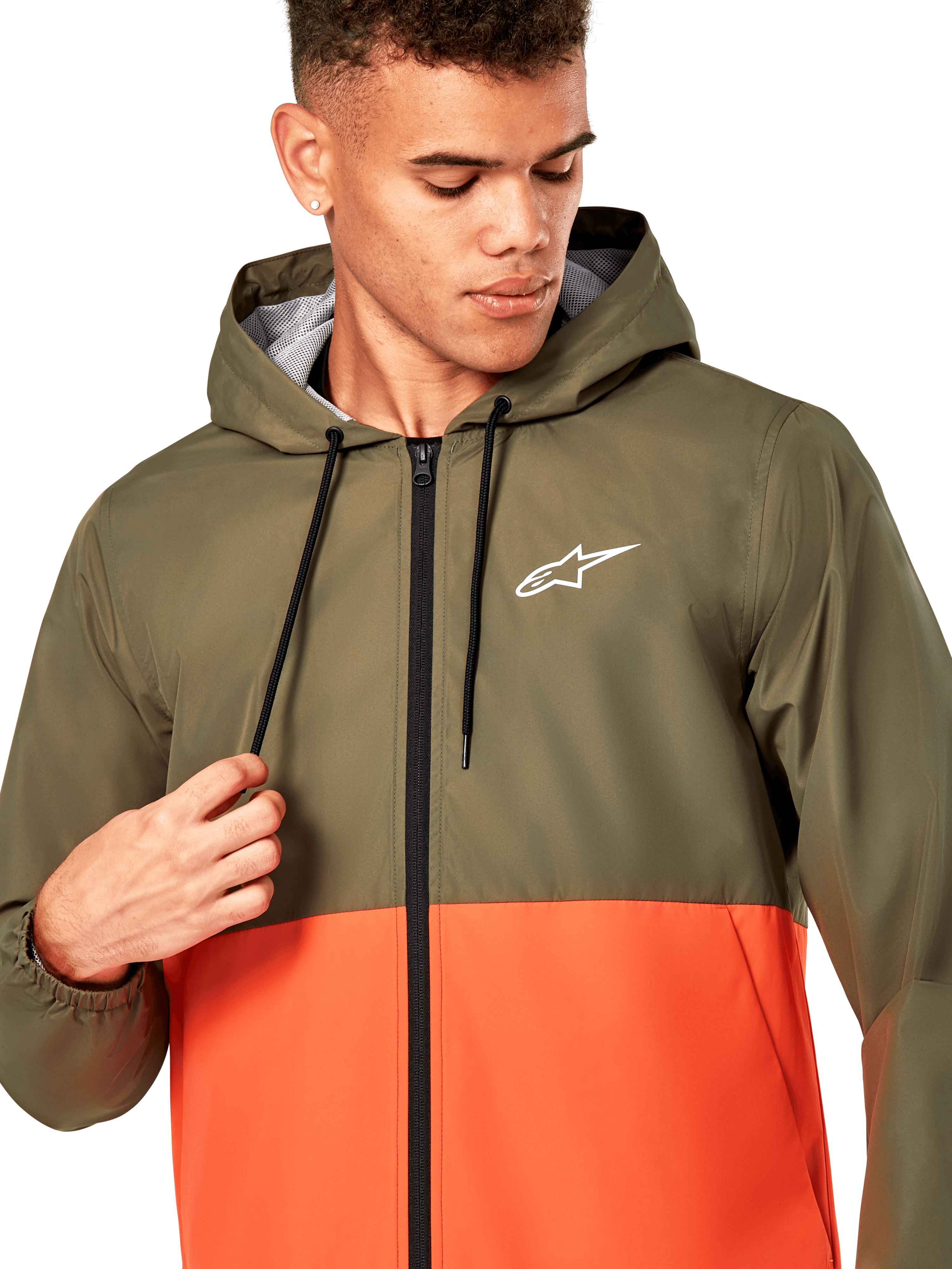 Alpinestars Speeder Windbreaker Jacket, chaqueta cortavientos ligera con capucha, diseño bicolor en verde oliva y naranja militar, logotipo de Alpinestars blanco en el pecho, cremallera y cordones negros, ropa deportiva casual inspirada en el automovilismo