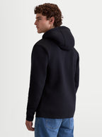 Alpinestars Ageless V3, sudadera con capucha para hombre, negra, mezcla de algodón suave y poliéster reciclado, vista trasera con diseño de capucha y puños de canalé, ropa deportiva lifestyle para entusiastas del motorsport.