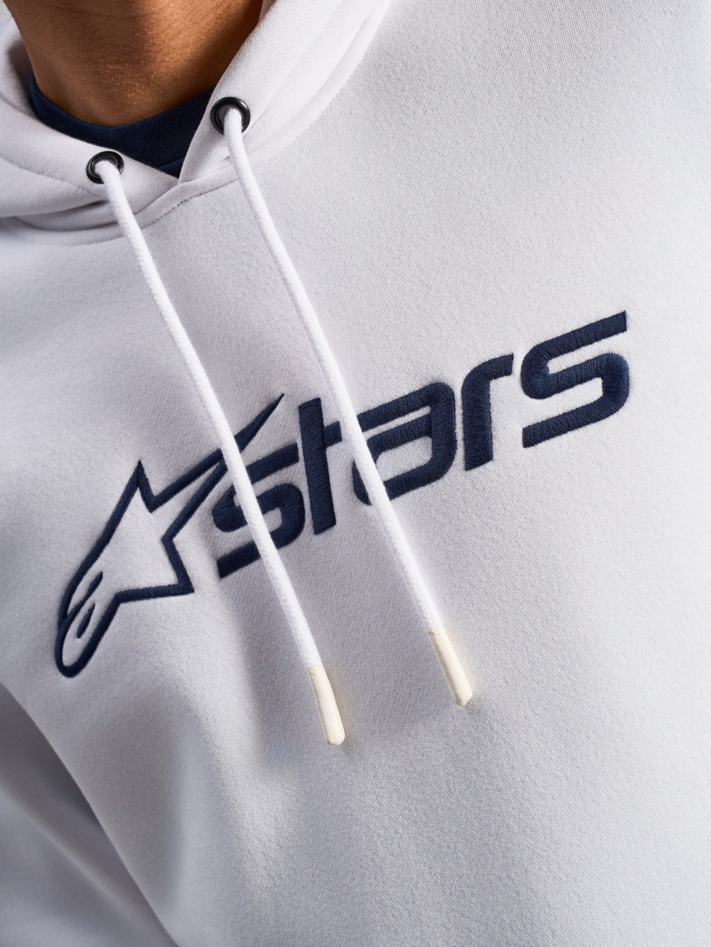 Alpinestars Blaze V3 Hoodie, White Navy, close-up of chest featuring navy blue front logo print and white drawstrings with dipped tips, casual motorsport streetwear
