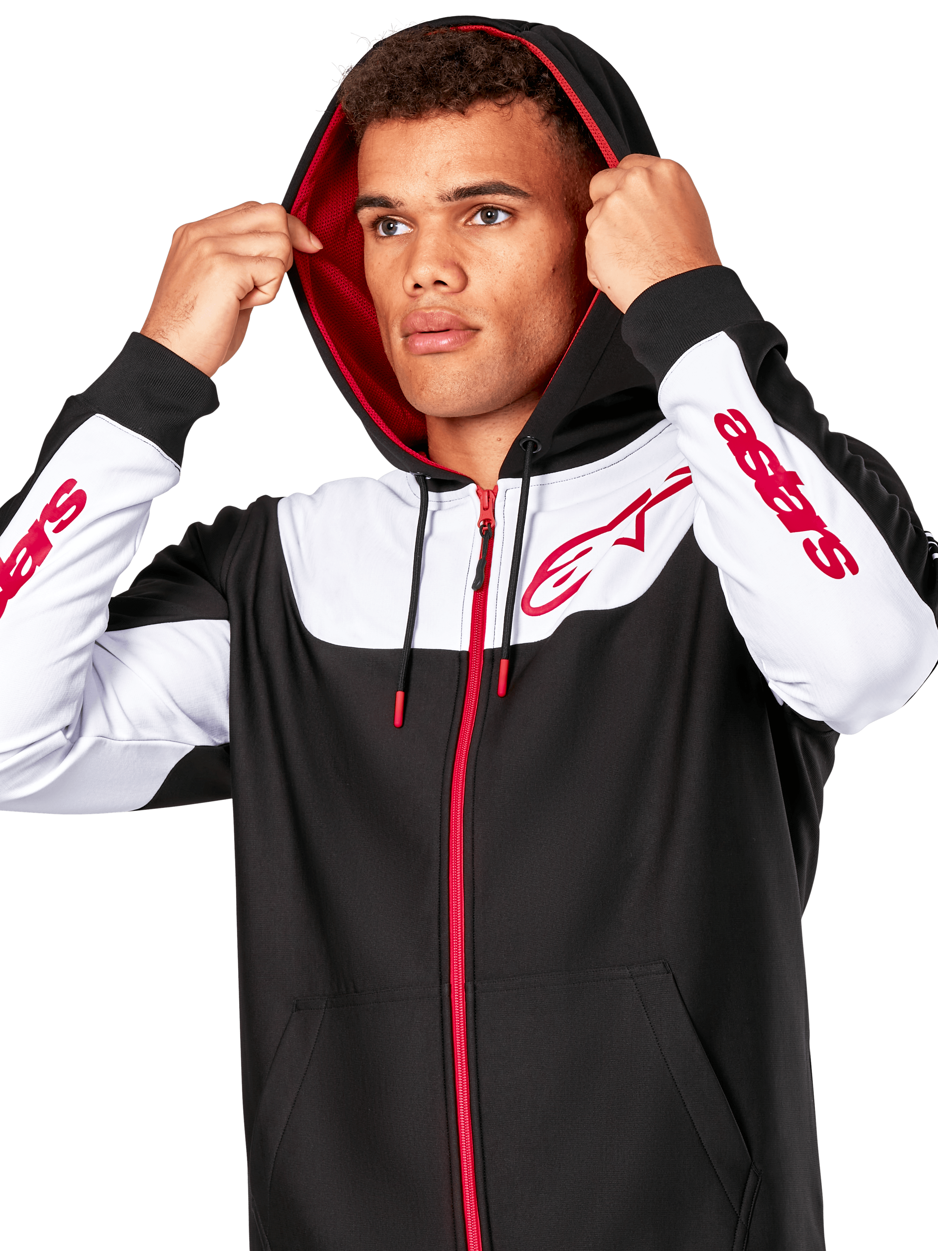 Alpinestars Sessions V3 Hoodie, negro, blanco y rojo, sudadera con cremallera frontal llevada por un hombre con la capucha puesta, con logotipos Alpinestars rojos en el pecho y las mangas, estilo streetwear casual de motorsport