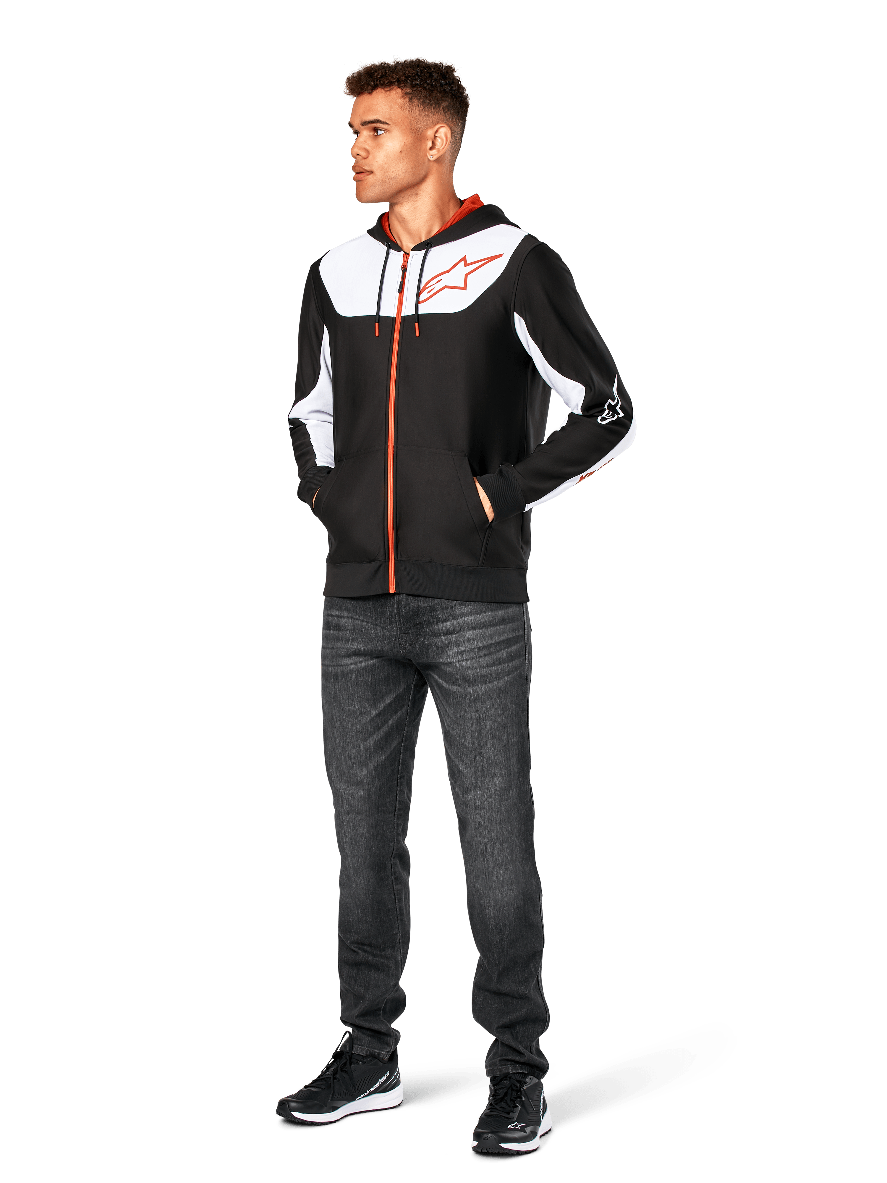 Sudadera Alpinestars Sessions V3, sudadera casual con cremallera frontal, negro, blanco y rojo, lucida por un modelo con vaqueros oscuros y zapatillas negras, con paneles de bloques de color blanco en el pecho y las mangas, detalles de cremallera y cordón en rojo, logotipo grande en el pecho, ropa urbana de forro polar inspirada en el automovilismo