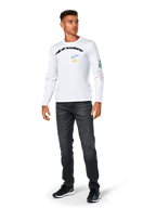 Alpinestars Brundo CSF Tee - Manga Larga, blanca, ropa deportiva casual, con el texto 'alpinestars' en negro en el pecho, un logotipo de estrella azul e iniciales 'AS' amarillas, gráficos coloridos en la manga, combinada con vaqueros oscuros y zapatillas negras