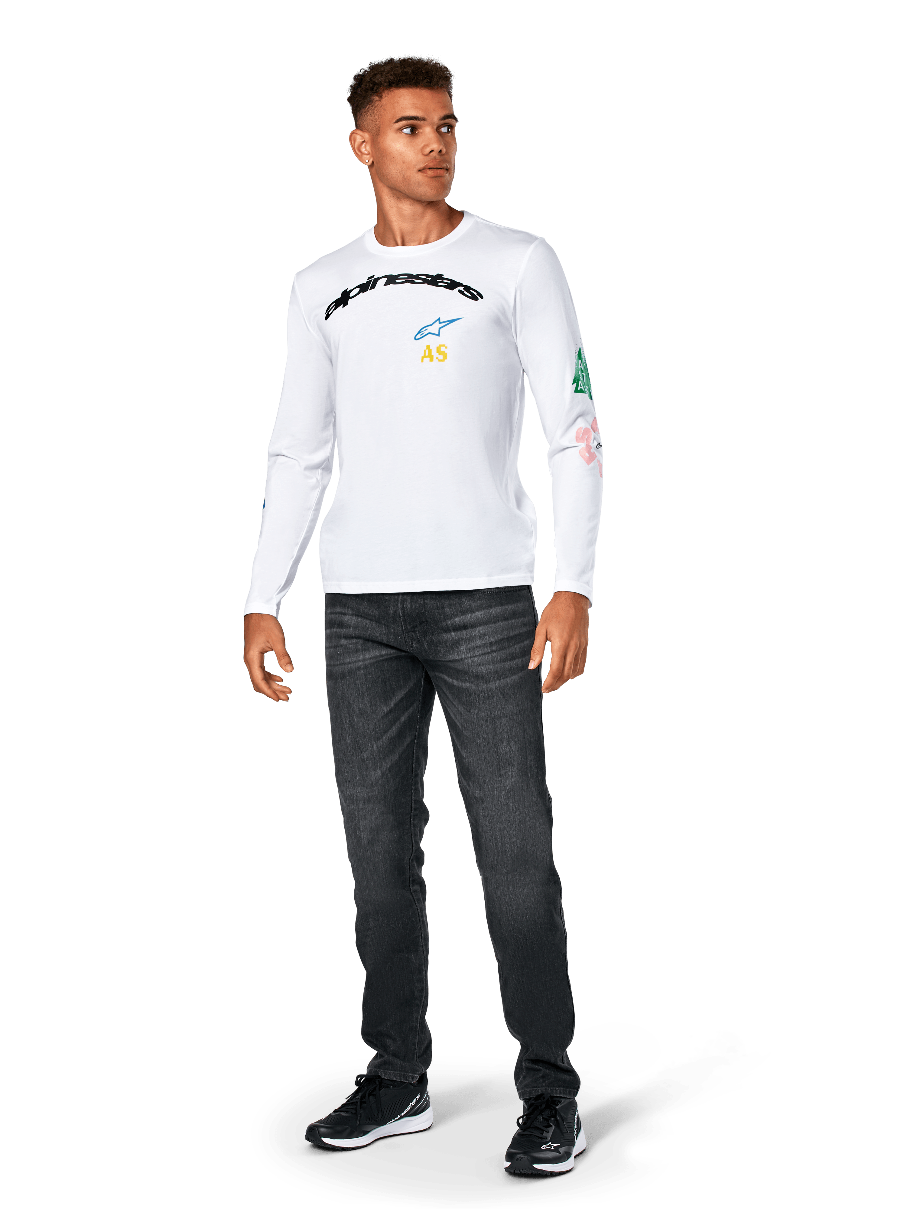 Alpinestars Brundo CSF Tee - Manga Larga, blanca, ropa deportiva casual, con el texto 'alpinestars' en negro en el pecho, un logotipo de estrella azul e iniciales 'AS' amarillas, gráficos coloridos en la manga, combinada con vaqueros oscuros y zapatillas negras