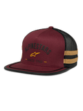 Alpinestars Backline Trucker Hat, gorra de malla en color granate y negro, logo de estrella amarilla y gráfico de herencia 'Since 1963', corona estructurada con visera plana y franjas laterales amarillo mostaza