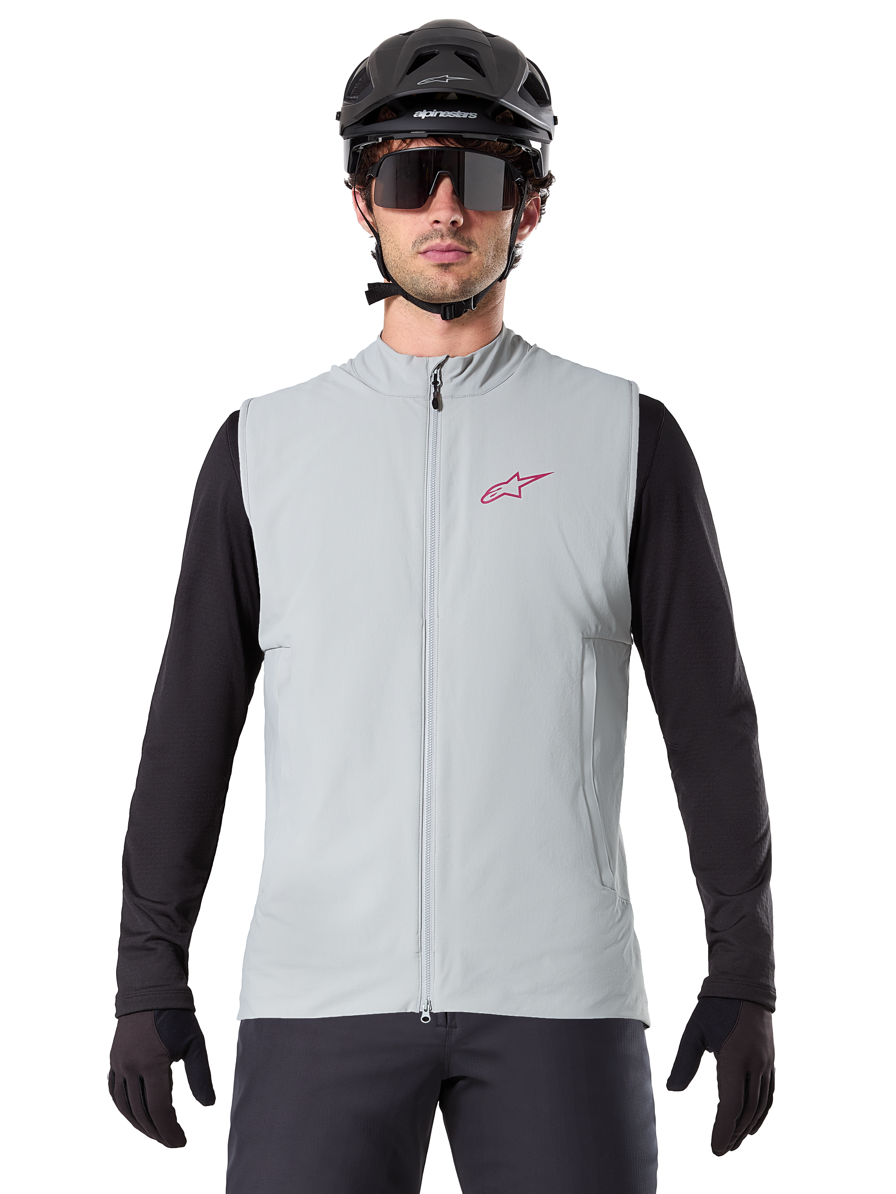 Chaleco Térmico Alpinestars A-Dura, chaleco de ciclismo, gris titanio, usado con un jersey negro de manga larga y casco de ciclismo negro, logo de estrella Alpinestars rojo en el pecho, ligero y con aislamiento para ciclismo de montaña