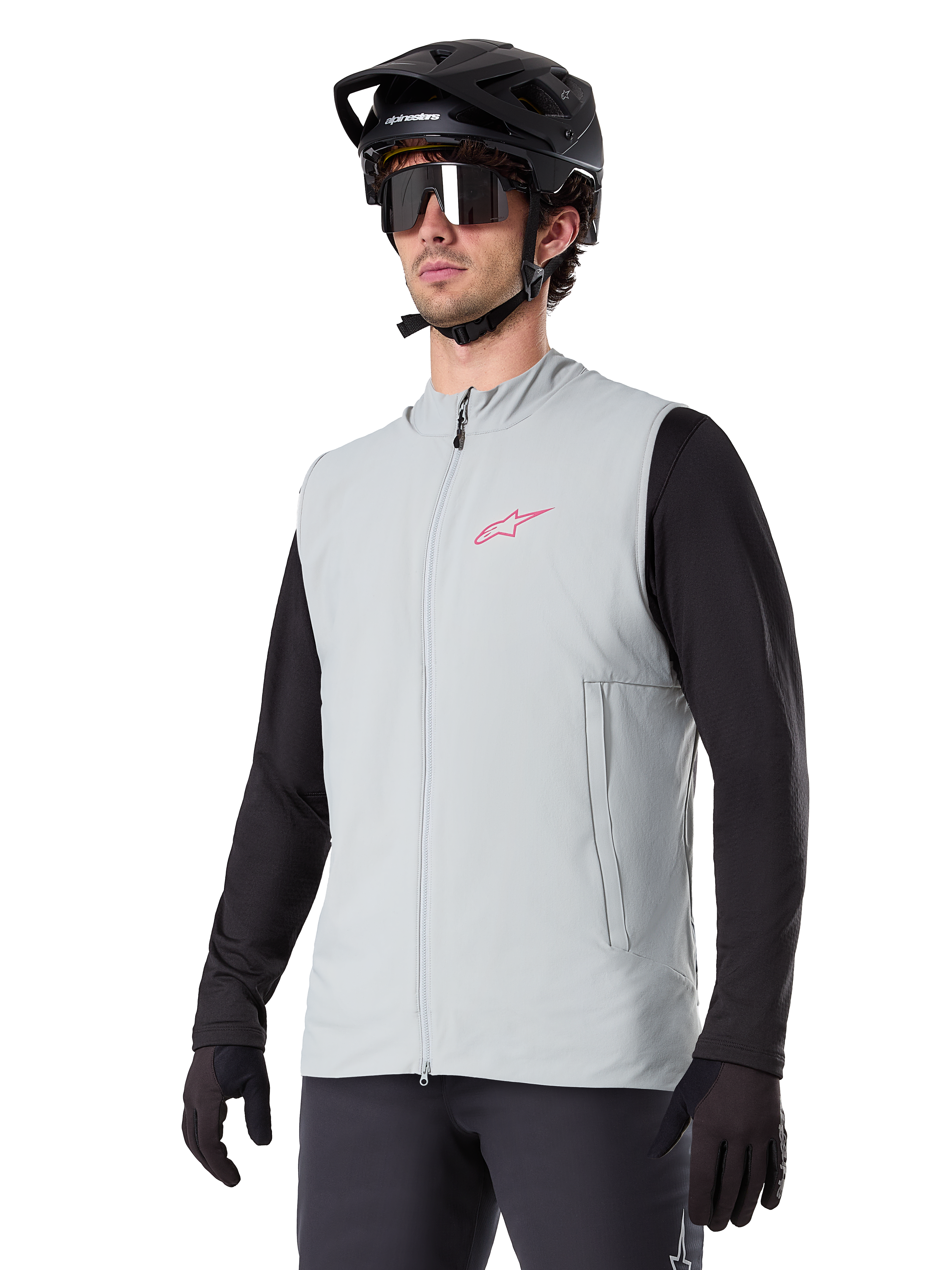 Alpinestars A-Dura Thermal Vest, Titanium Gray, cycling insulated vest, worn over a black long-sleeve shirt with a black mountain bike helmet and gloves, featuring a pink chest logo and vertical zippered side pockets