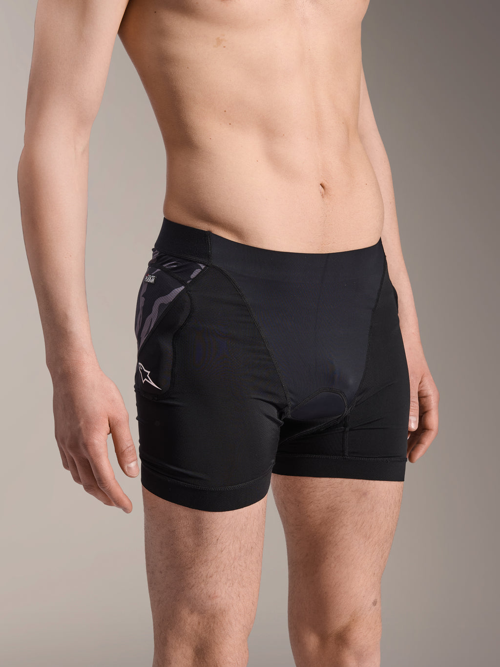 Alpinestars A-Motion Plasma Protection Boxers, pantalones cortos negros de capa base para ciclismo, con protector de cadera con patrón de camuflaje y logo Astar blanco, tejido de malla transpirable, equipo de protección para ciclismo de montaña