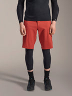 Alpinestars A-Motion Plasma Knee Sleeve, protector de rodilla de MTB negro, usado con pantalones cortos rojos y camiseta negra de manga larga, diseño ergonómico de perfil delgado, construcción de malla ligera para conducción fuera de carretera