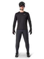 Alpinestars A-Dura Thermal Pant, pantalón térmico de ciclismo en color negro, usado por un ciclista con equipo completo de bicicleta de montaña que incluye jersey negro de manga larga, casco y gafas de sol, pantalones resistentes con ajuste regular para rutas en climas fríos