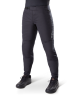 Alpinestars A-Dura Thermal Pant, pantalones de ciclismo de montaña negros, usados con zapatillas de ciclismo negras, con cierre de trinquete en la cintura, pequeño logo blanco en el muslo y diseño ajustado para rodar en climas fríos