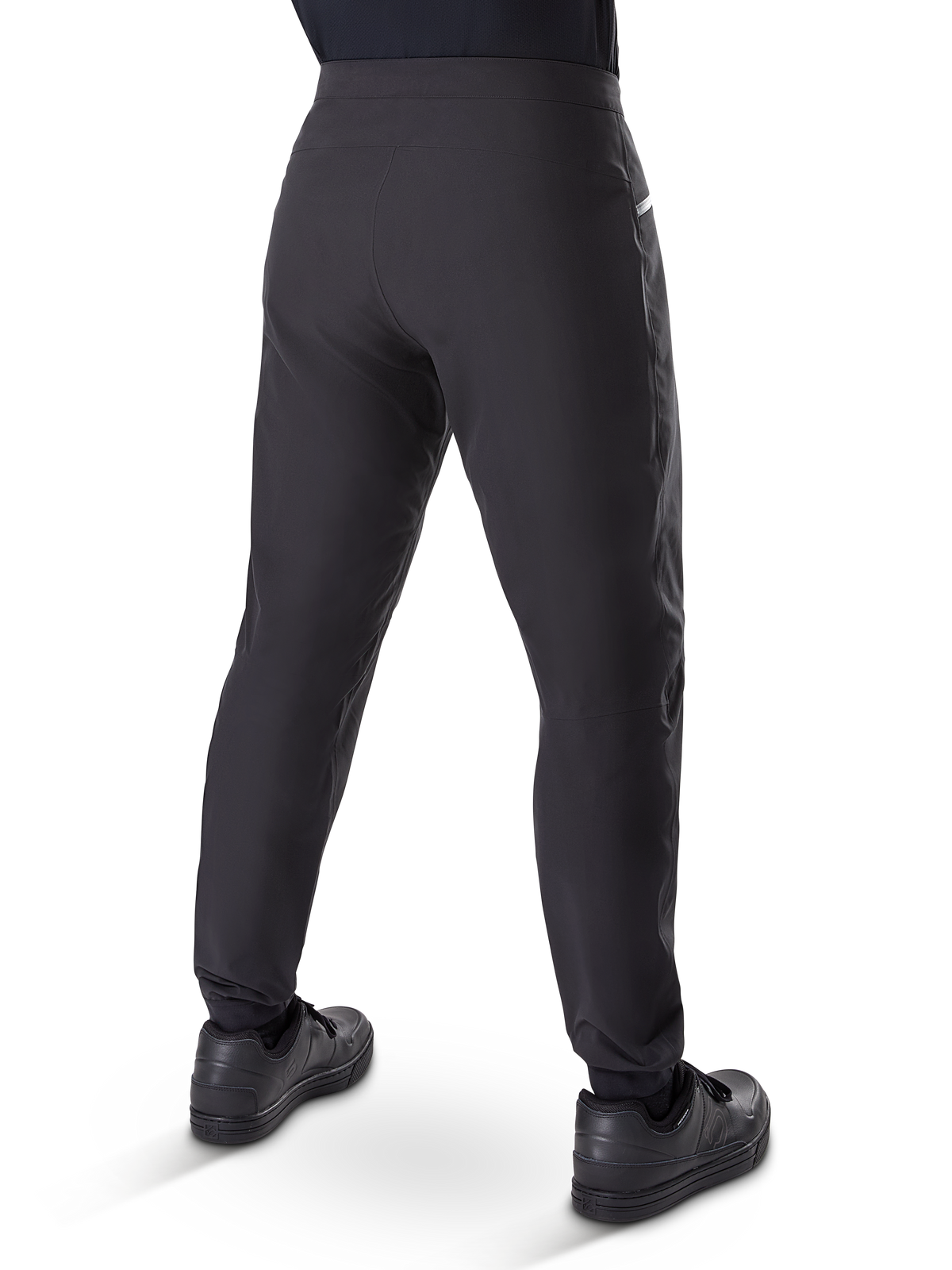 Pantalones impermeables Alpinestars A-Dura, pantalones de mountain bike, negro, vista trasera con zapatillas negras, con membrana duradera de 3 capas, ajuste regular y puños elásticos para ciclismo de montaña
