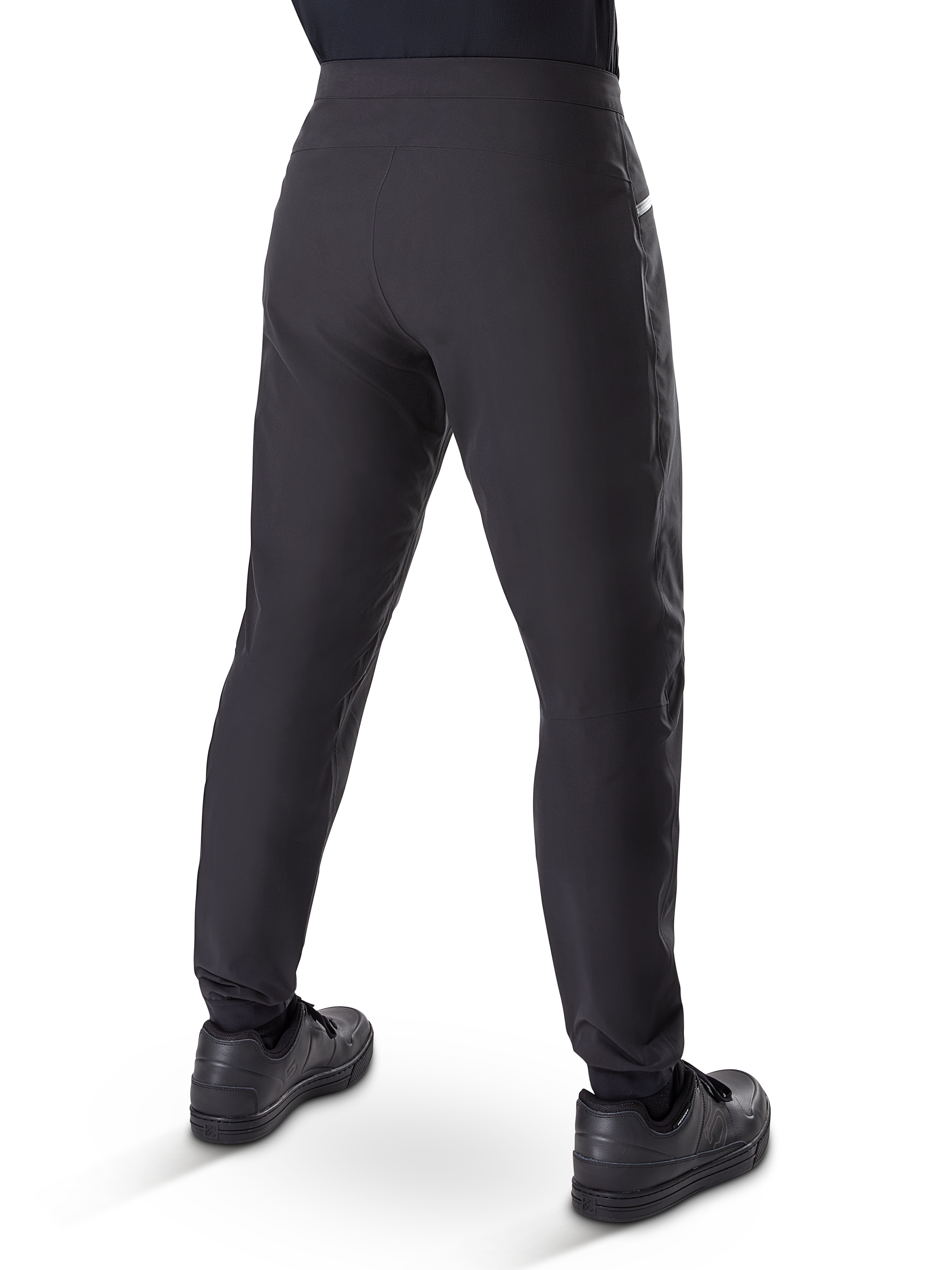 Pantalones impermeables Alpinestars A-Dura, pantalones de mountain bike, negro, vista trasera con zapatillas negras, con membrana duradera de 3 capas, ajuste regular y puños elásticos para ciclismo de montaña