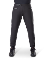 Pantalones impermeables Alpinestars A-Dura, negro, pantalones de ciclismo de montaña con cierre de trinquete en la cintura y bolsillos con cremallera, vista frontal en modelo con zapatillas negras, equipo impermeable duradero para MTB