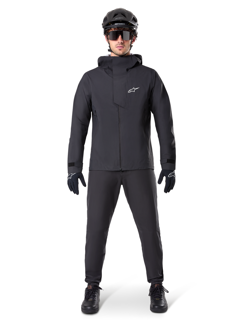 Alpinestars A-Dura Waterproof Pants, pantalones negros de MTB, parte de un conjunto completo de equipamiento de ciclismo de montaña totalmente negro con chaqueta técnica impermeable, casco negro, gafas de sol y guantes, diseñado para la conducción todoterreno en condiciones de clima húmedo.
