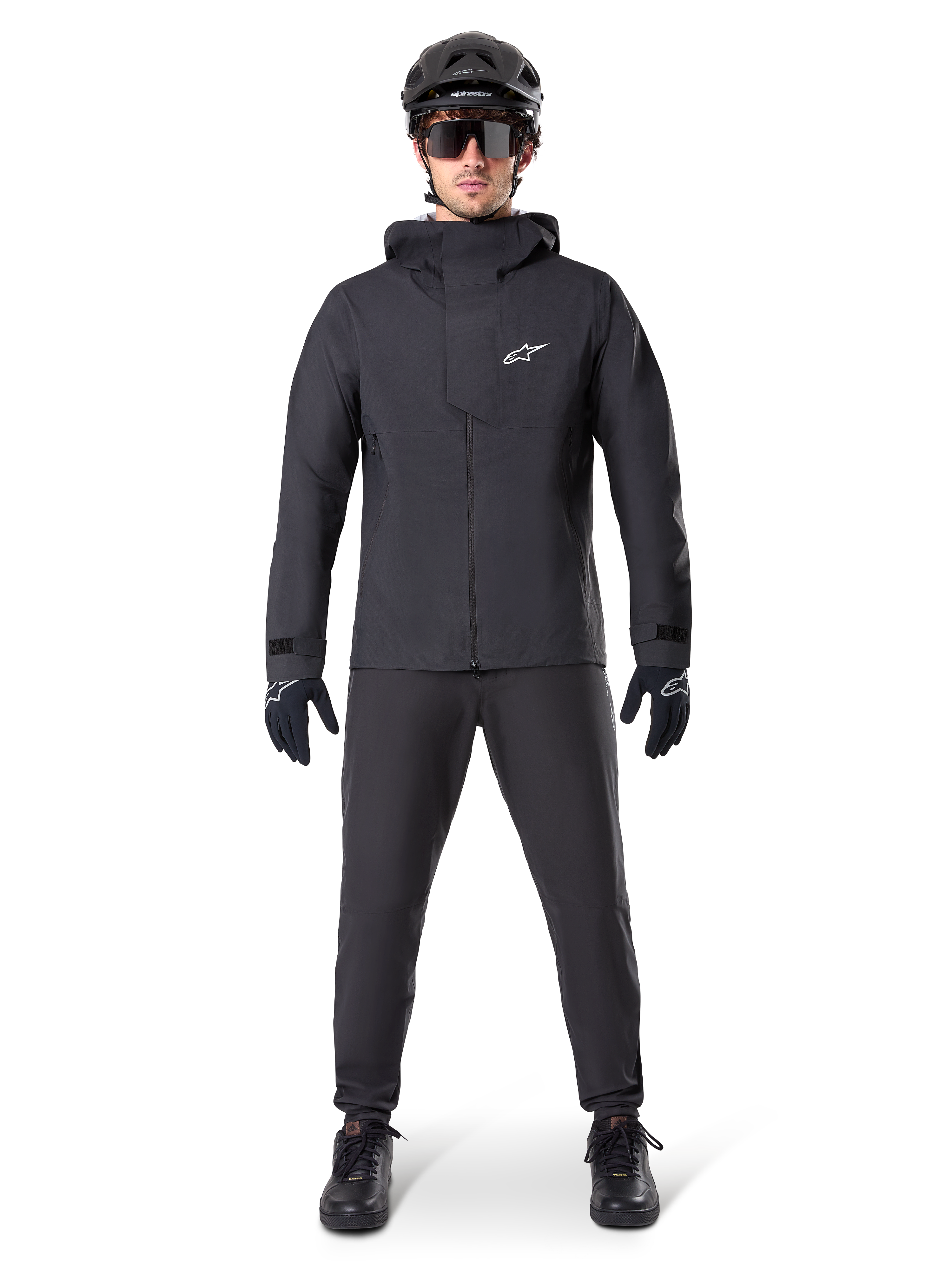 Alpinestars A-Dura Waterproof Pants, pantalones negros de MTB, parte de un conjunto completo de equipamiento de ciclismo de montaña totalmente negro con chaqueta técnica impermeable, casco negro, gafas de sol y guantes, diseñado para la conducción todoterreno en condiciones de clima húmedo.