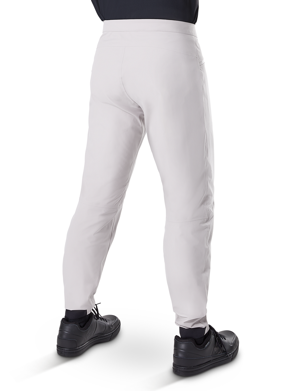 Alpinestars A-Dura Waterproof Pants, pantalones de ciclismo MTB, Gris Titanio, vista trasera que muestra las piernas entalladas y los puños elásticos, usados con zapatillas negras, equipo técnico impermeable para ciclismo de montaña