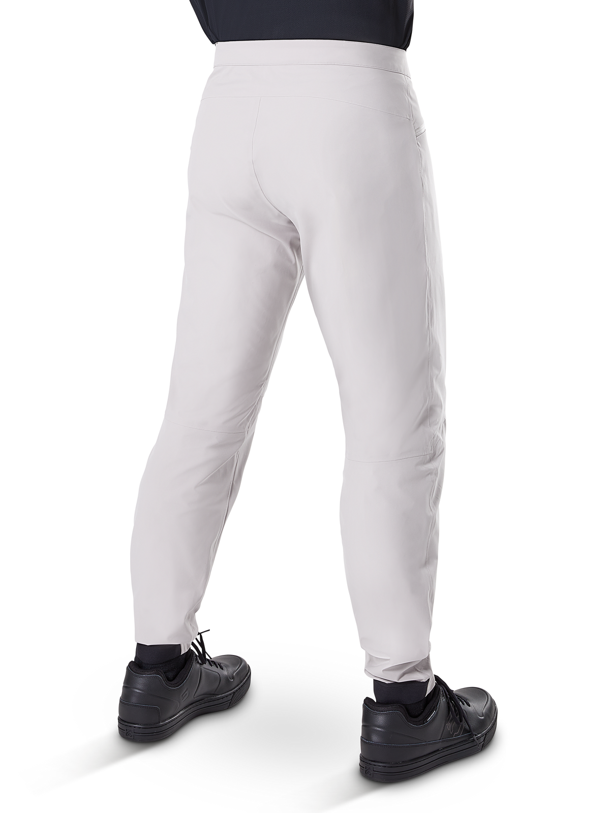 Alpinestars A-Dura Waterproof Pants, pantalones de ciclismo MTB, Gris Titanio, vista trasera que muestra las piernas entalladas y los puños elásticos, usados con zapatillas negras, equipo técnico impermeable para ciclismo de montaña