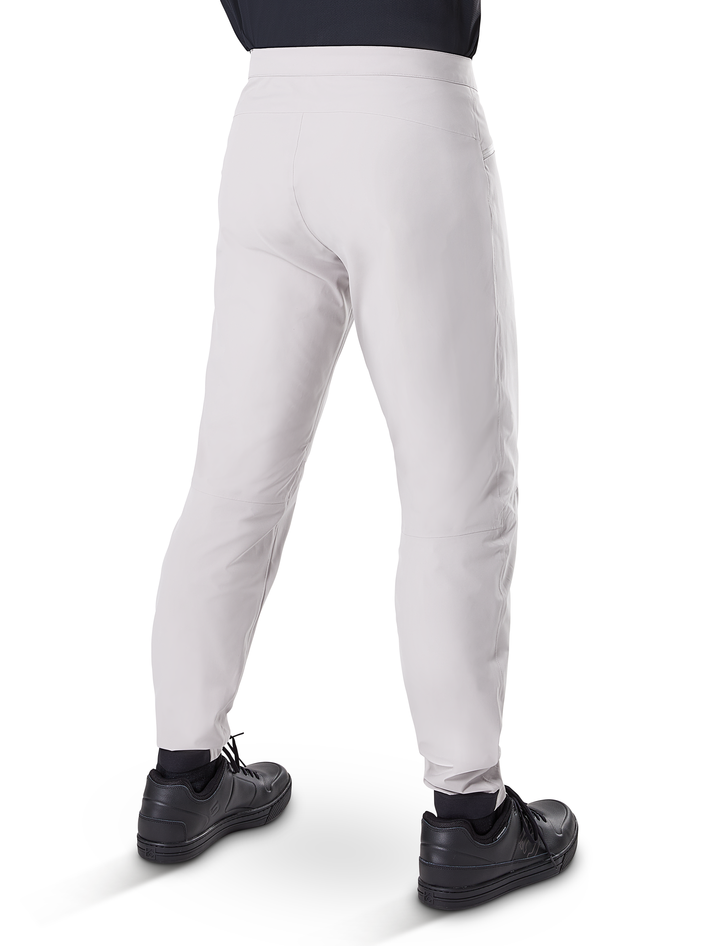 Alpinestars A-Dura Waterproof Pants, pantalones de ciclismo MTB, Gris Titanio, vista trasera que muestra las piernas entalladas y los puños elásticos, usados con zapatillas negras, equipo técnico impermeable para ciclismo de montaña