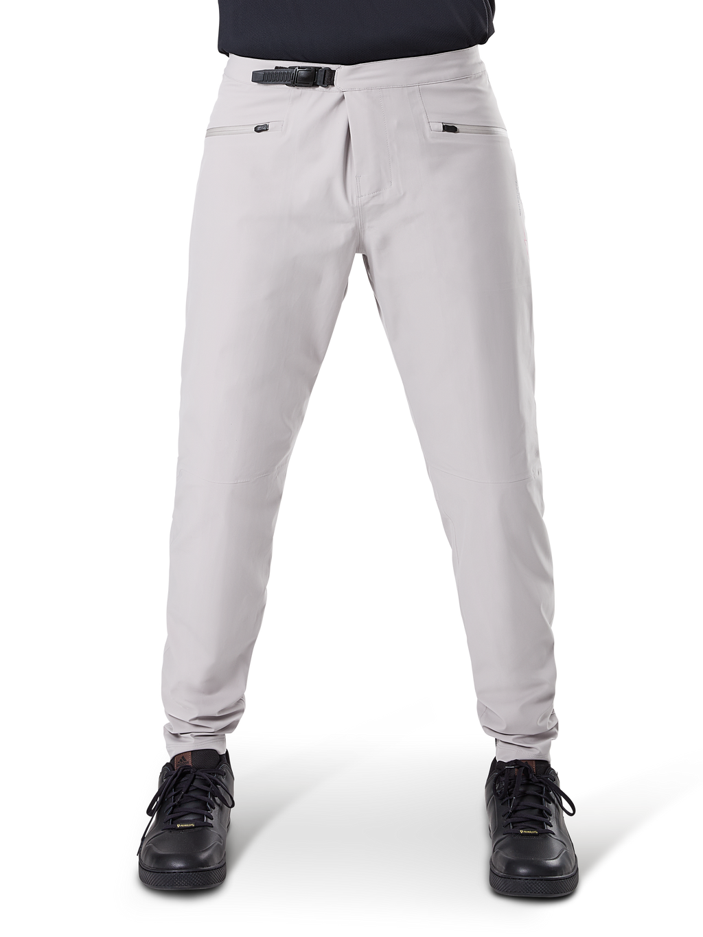 Pantalones impermeables Alpinestars A-Dura, pantalones de ciclismo MTB, gris titanio, vista frontal, con cierre de trinquete negro en la cintura y dos bolsillos con cremallera, puños elásticos, usados con zapatillas negras, equipo técnico impermeable para ciclismo de montaña