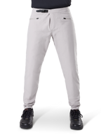 Pantalones impermeables Alpinestars A-Dura, pantalones de ciclismo MTB, gris titanio, vista frontal, con cierre de trinquete negro en la cintura y dos bolsillos con cremallera, puños elásticos, usados con zapatillas negras, equipo técnico impermeable para ciclismo de montaña