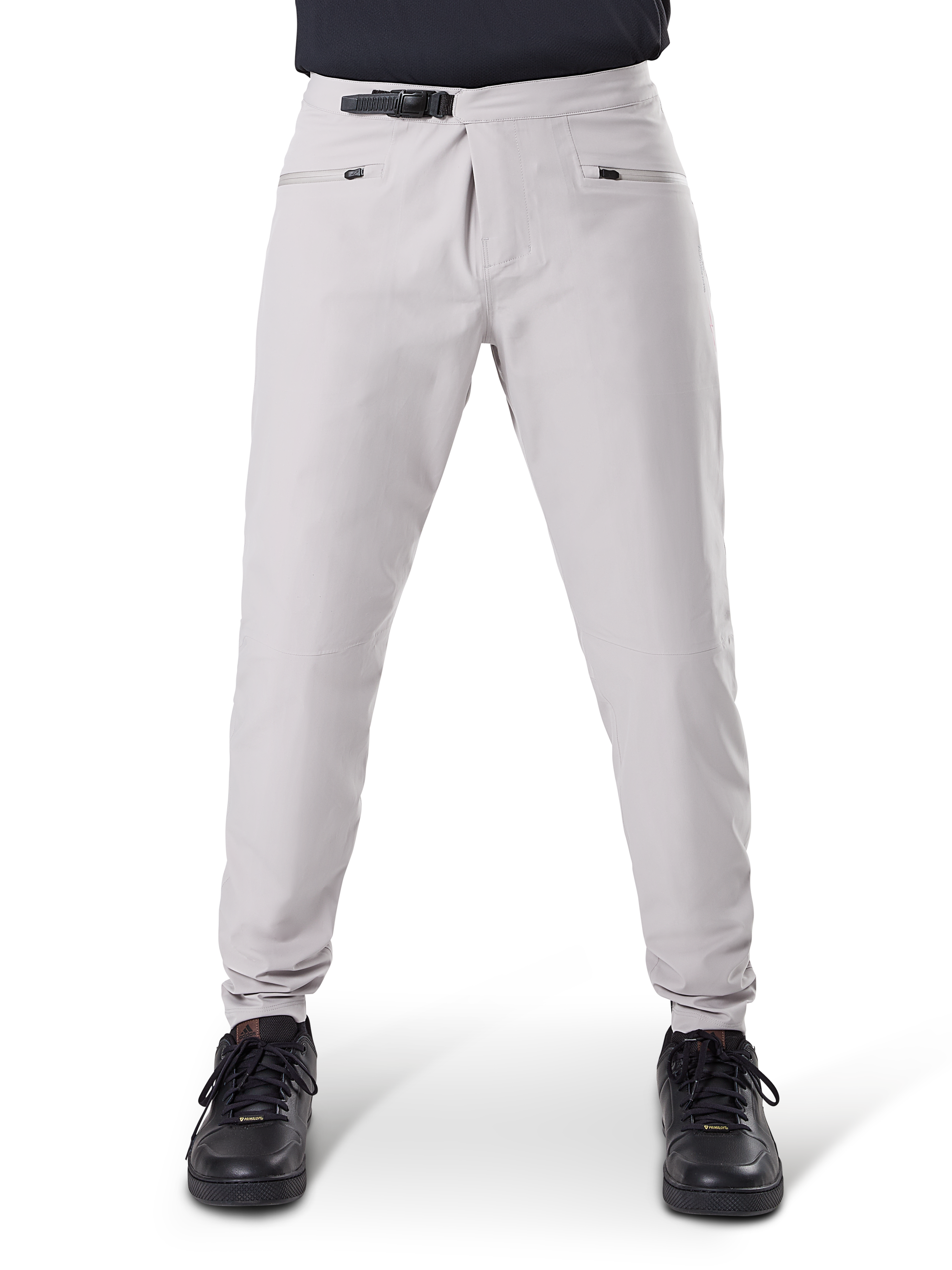 Pantalones impermeables Alpinestars A-Dura, pantalones de ciclismo MTB, gris titanio, vista frontal, con cierre de trinquete negro en la cintura y dos bolsillos con cremallera, puños elásticos, usados con zapatillas negras, equipo técnico impermeable para ciclismo de montaña
