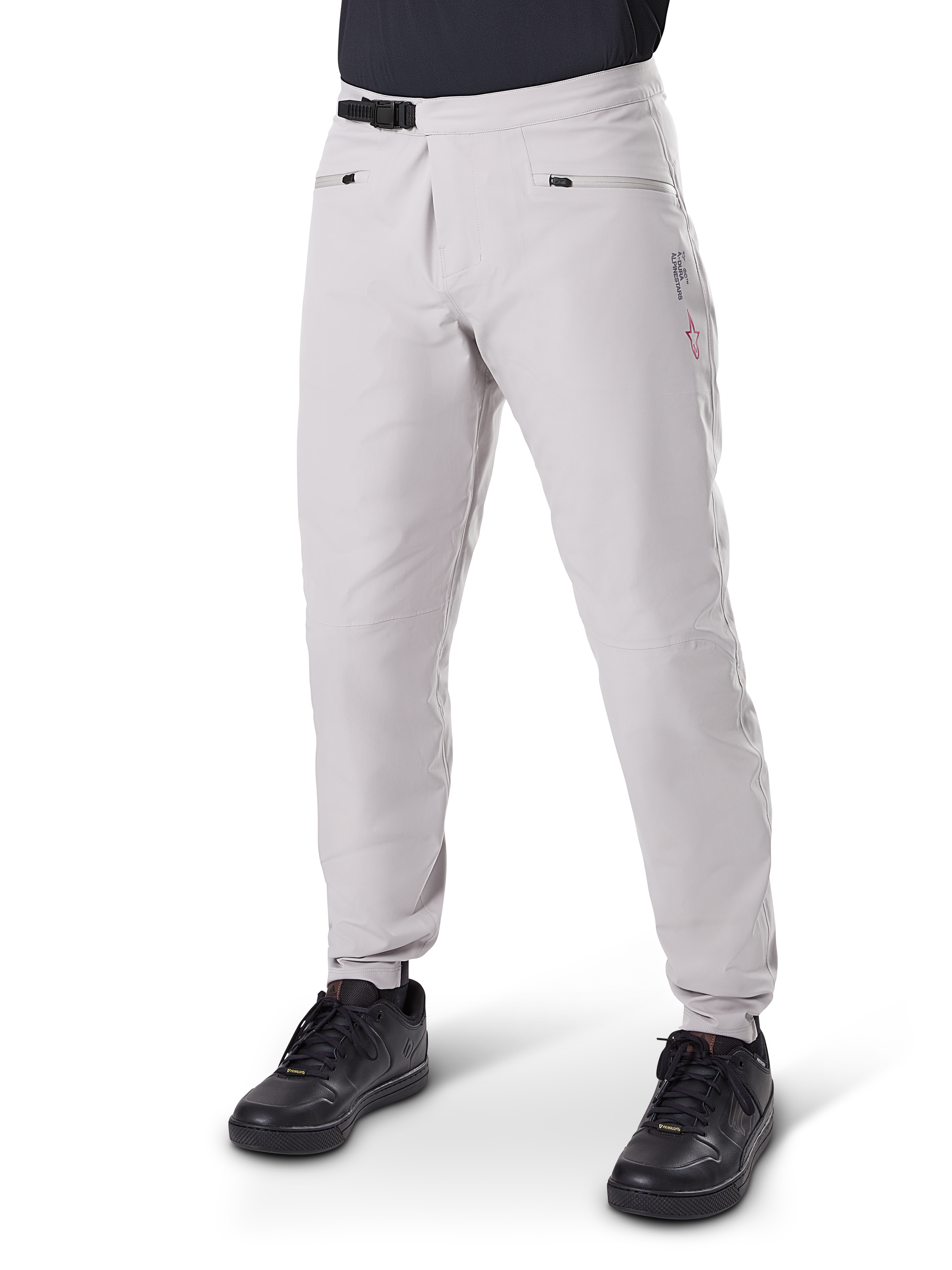 Alpinestars A-Dura Waterproof Pants, pantalones de ciclismo de montaña, gris titanio, con cierre de trinquete negro en la cintura y bolsillos con cremallera, piernas ajustadas con puños elásticos, usados con calzado negro, construcción impermeable 3L duradera para ciclismo todoterreno