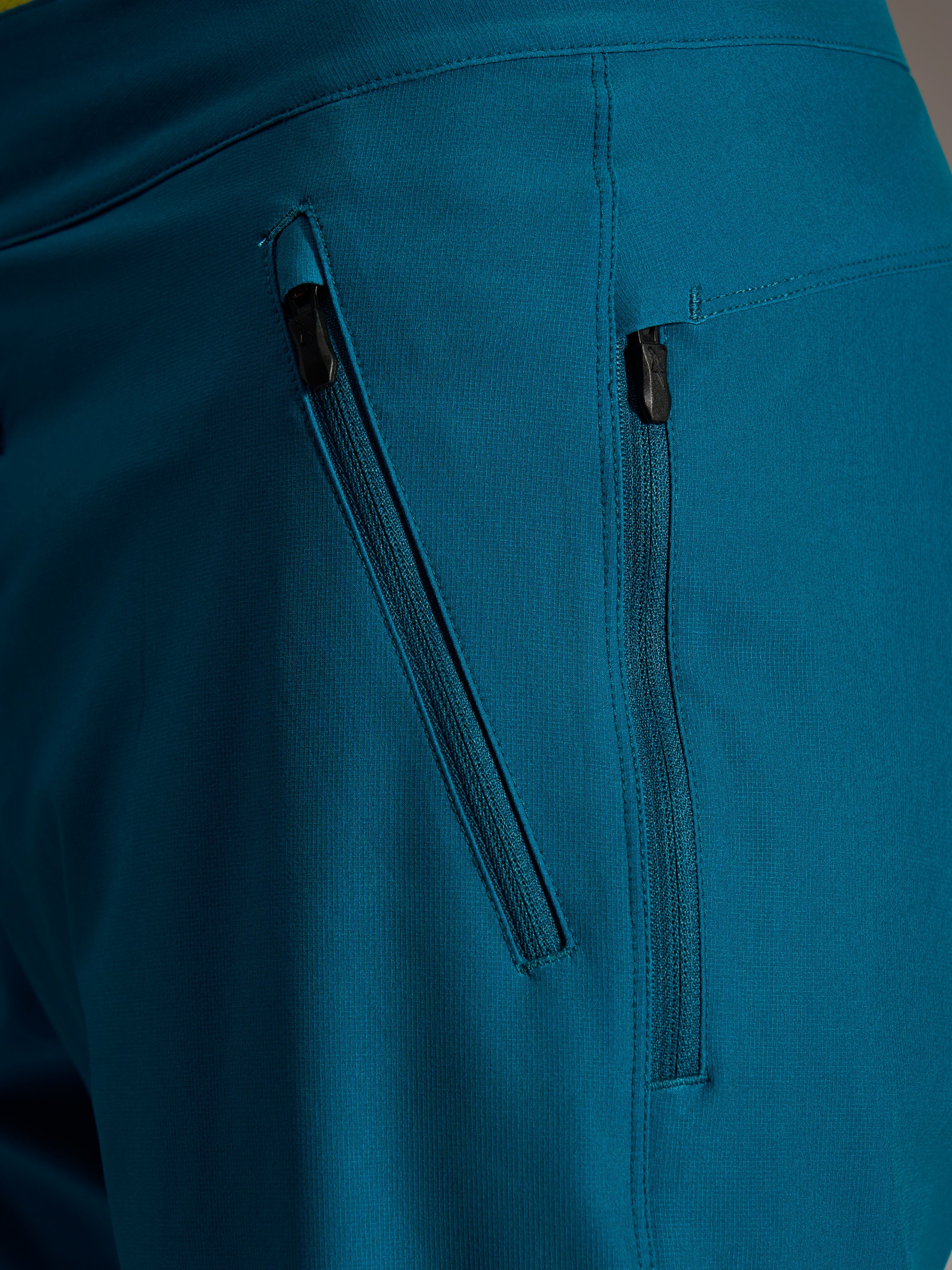 Bolsillos con doble cremallera en los shorts Alpinestars A-Dura Ride Blue Green, con tejido elástico en 4 direcciones.