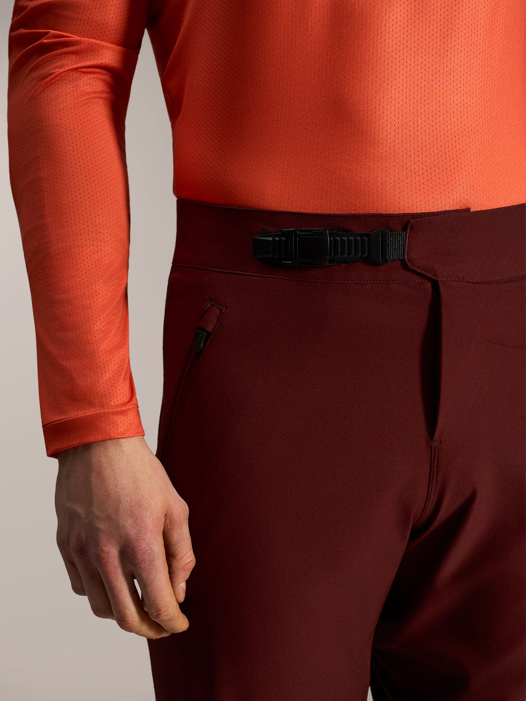 Pantalones cortos A-Dura Ride burdeos, detalle de cierre de trinquete frontal y bolsillo con cremallera para MTB.
