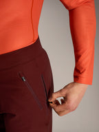 Pantalones cortos Alpinestars A-Dura Ride en bordeaux, detalle de mano abriendo el bolsillo lateral con cremallera.