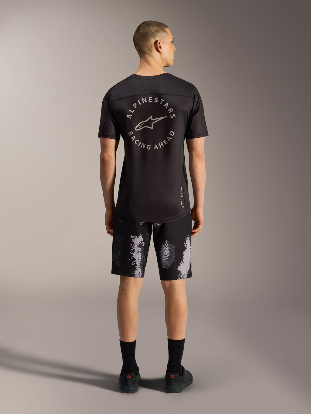 Pantalones cortos A-Dura Ride en Black Camo, duradero diseño de MTB elástico para hombre visto desde atrás en estudio.