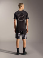 Pantalones cortos A-Dura Ride en Black Camo, duradero diseño de MTB elástico para hombre visto desde atrás en estudio.