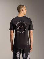 Pantalones cortos Alpinestars A-Dura Ride Black Camo y jersey MTB negro con logo circular trasero, vista posterior.