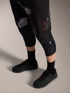 Pantalones cortos Alpinestars A-Dura Ride en Black Camo, equipo MTB con logo naranja, rodilleras y zapatillas.