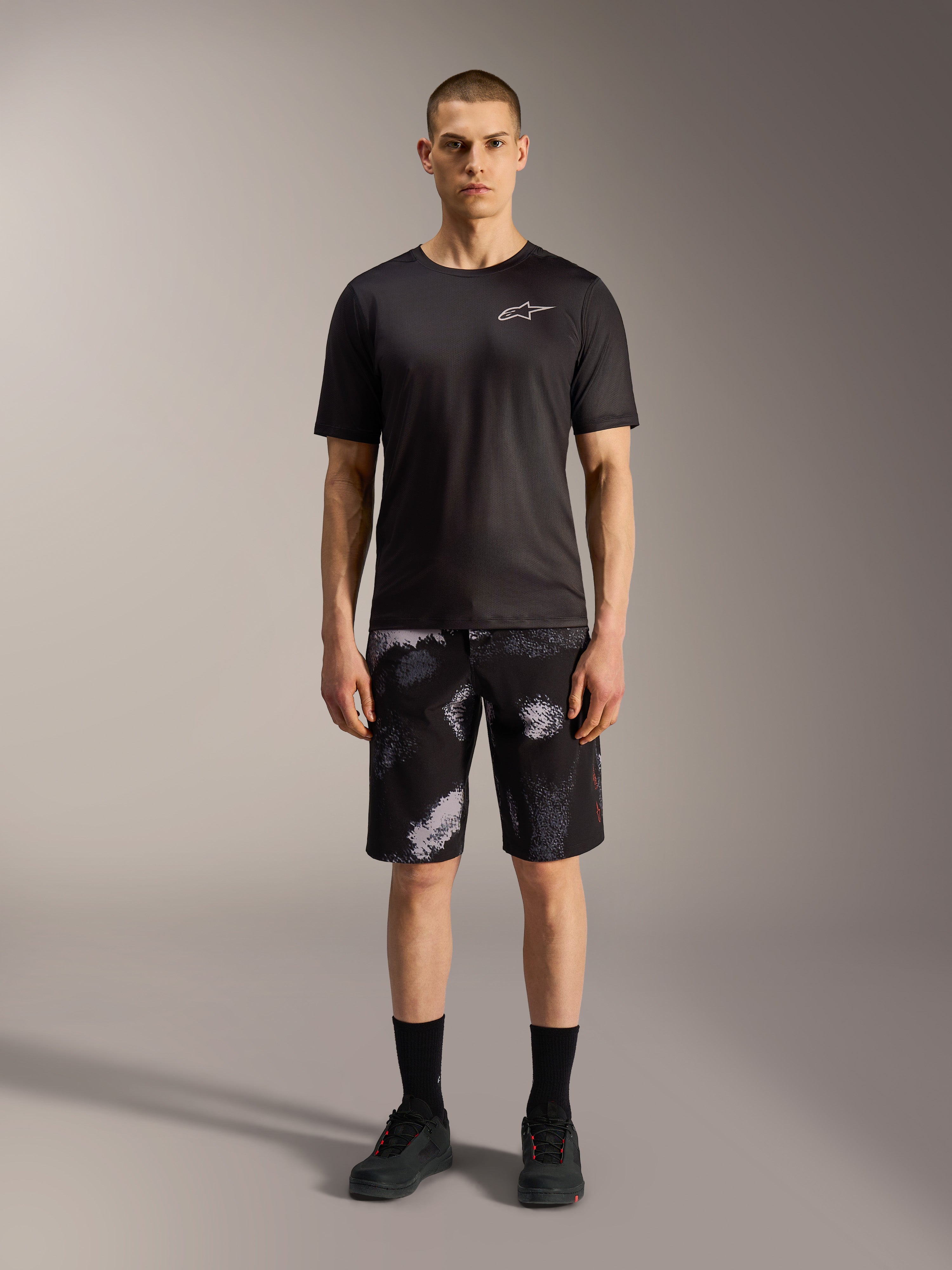 Pantalones cortos Alpinestars A-Dura Ride en Black Camo con camiseta técnica negra, versatilidad para ciclismo de montaña.