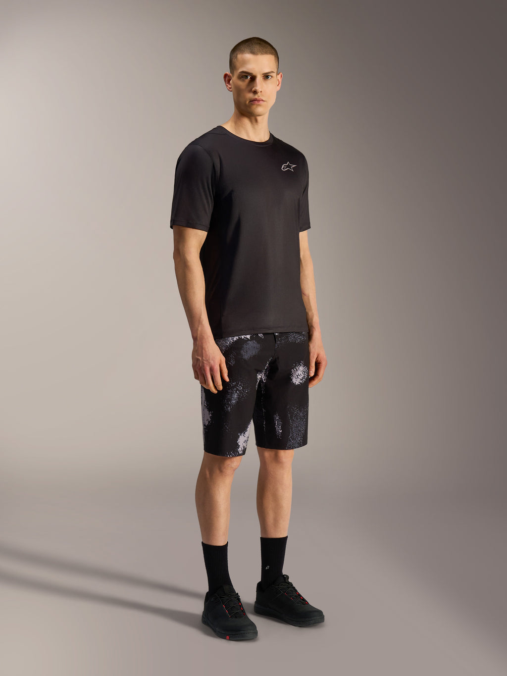 A-Dura Ride Pantalones cortos en Black Camo, shorts de MTB Alpinestars con camuflaje gris, jersey y calzado negro.