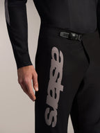Pantalones Alpinestars A-Supra Elite negros, cierre de trinquete en la cintura y logotipo Astars gris en el muslo.