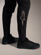 Pantalones MTB A-Supra Elite negros, logotipo Astars plateado en la pierna, diseño de alto rendimiento para ciclismo.