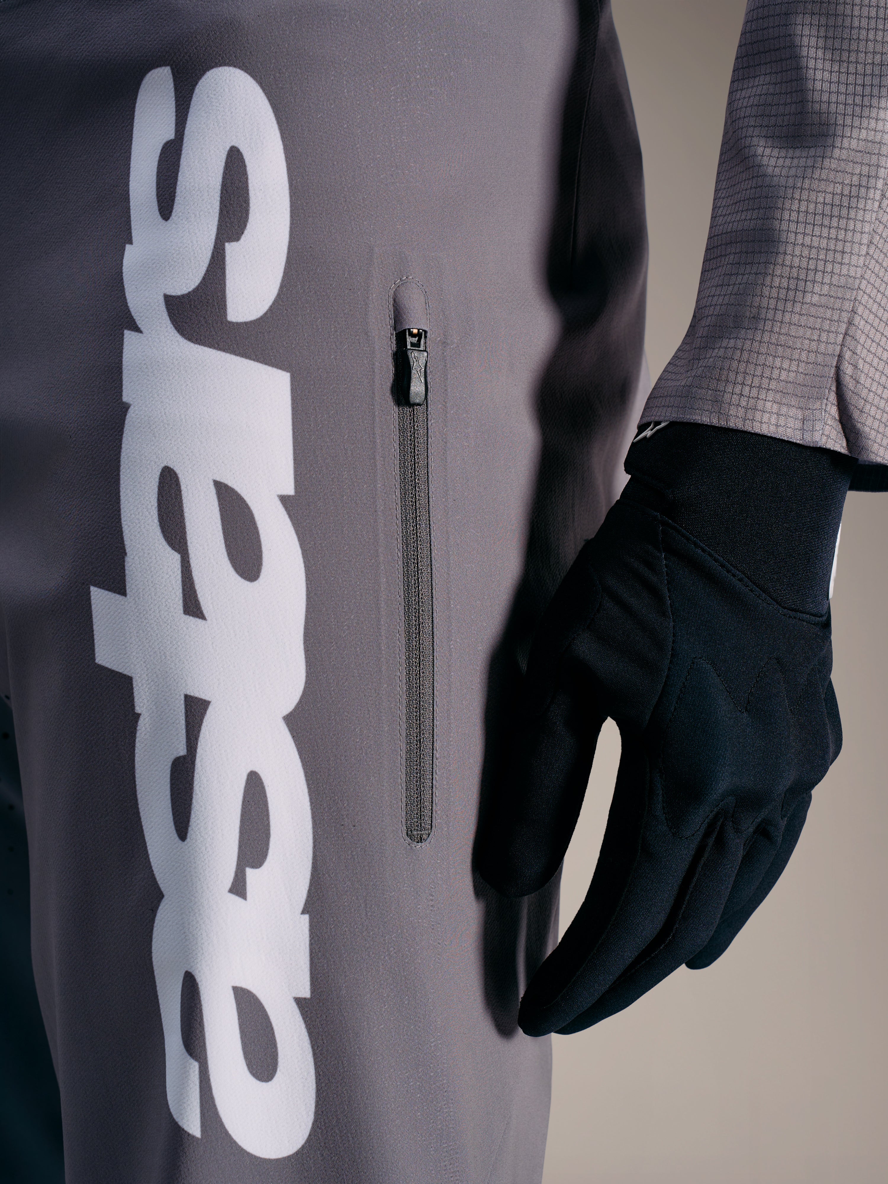 Pantalones A-Supra Elite Faded Gray con logo blanco y bolsillo vertical con cremallera, diseñados para el rendimiento en MTB.