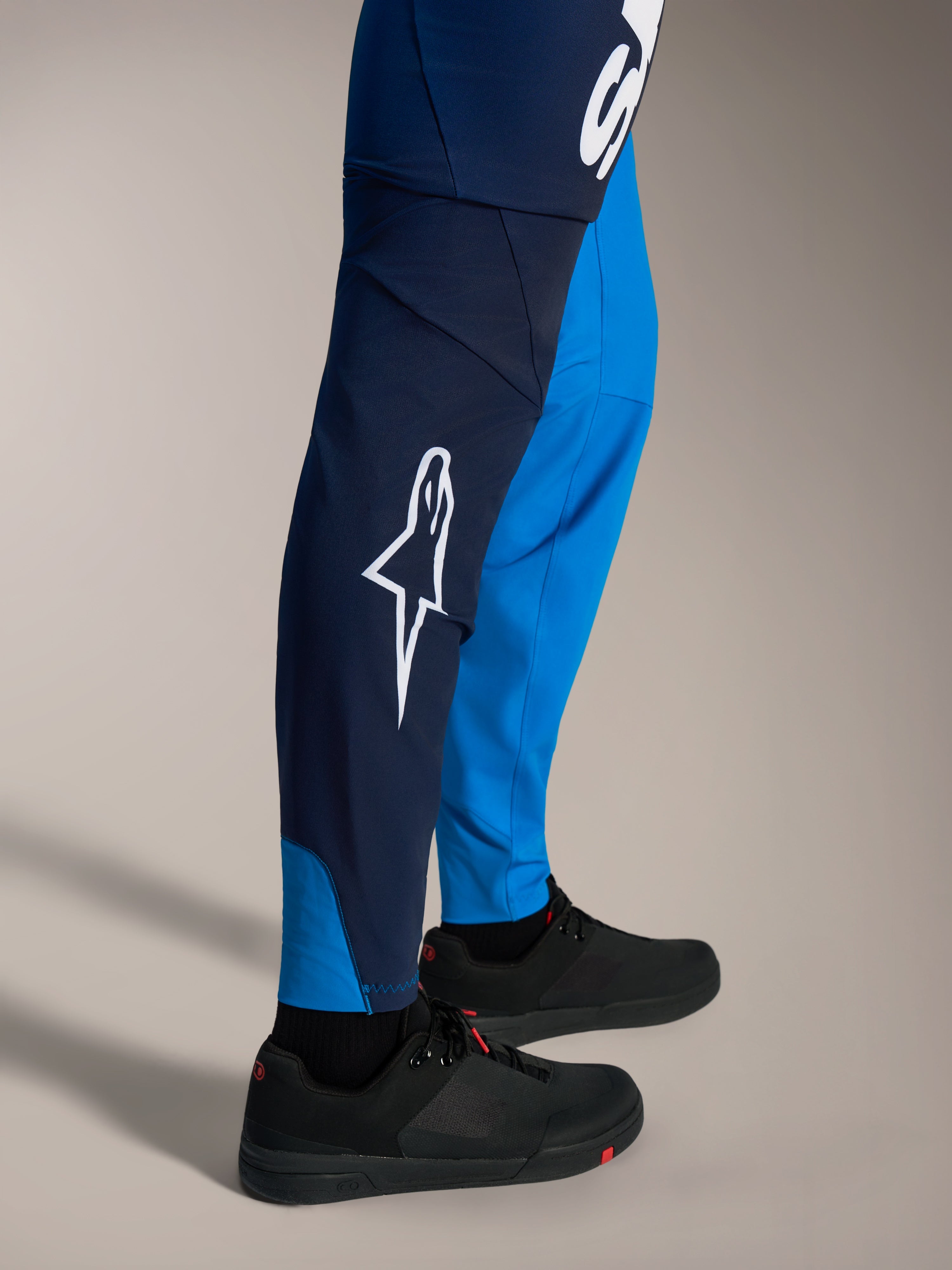 Pantalones de MTB Alpinestars A-Supra Elite, azul brillante degradado, con logo Astars blanco y diseño ajustado.