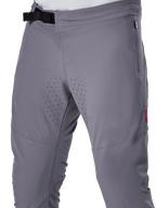 Pantalones Alpinestars A-Aria Elite, pantalones de ciclismo MTB, gris oscuro, vista de cerca con el cierre de hebilla magnética, bolsillo lateral con cremallera y perforaciones de ventilación cortadas con láser en la parte interna de los muslos para un rendimiento óptimo en senderos.
