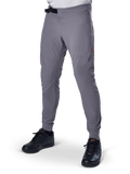Alpinestars A-Aria Elite Pants, pantalones de MTB gris oscuro, paneles perforados con láser en los muslos, cierre de hebilla magnética negra, bolsillo con cremallera, detalle de logo rojo, ajuste de rendimiento slim, combinados con zapatillas negras