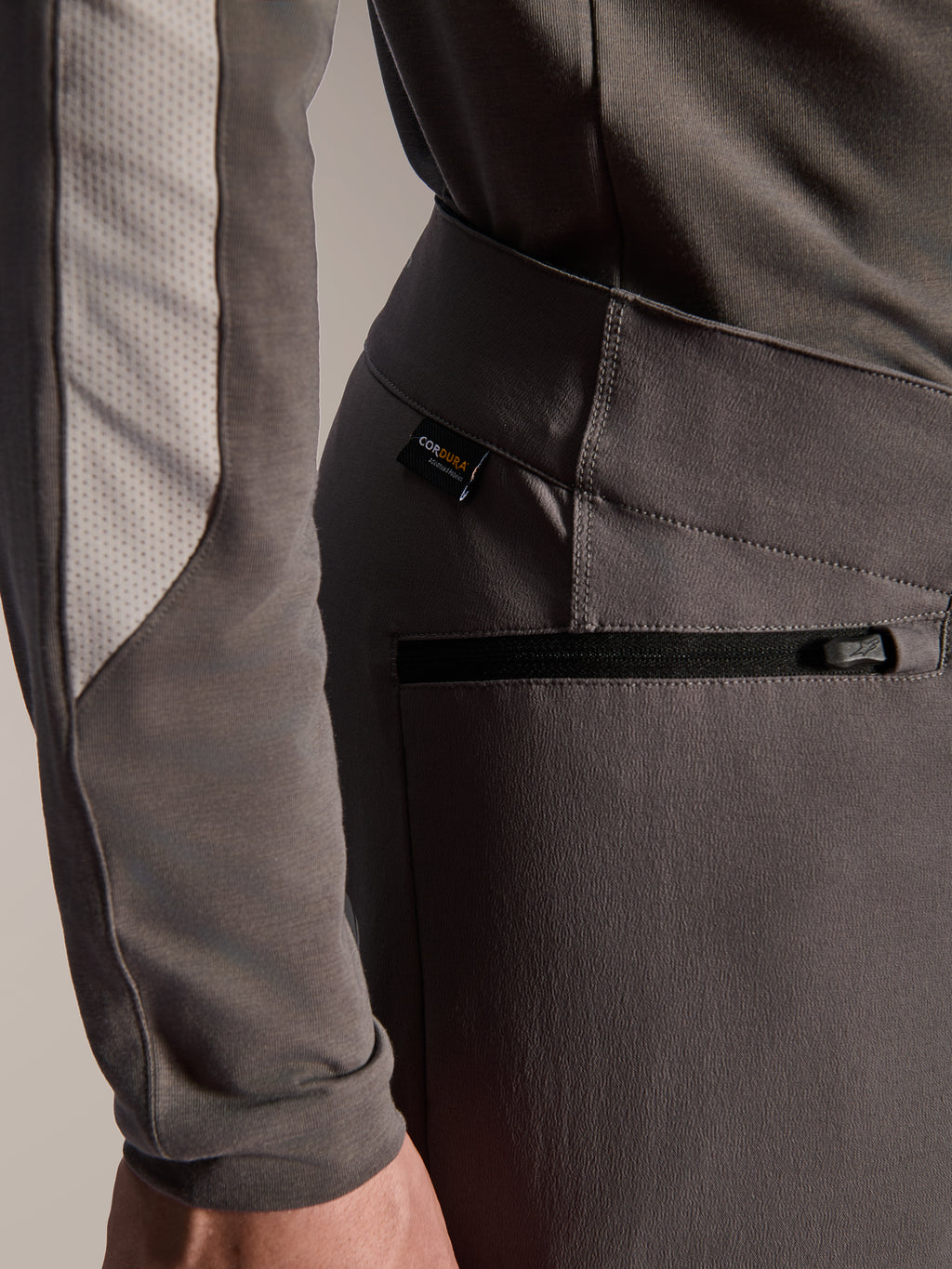 Alpinestars A-Dura Elite Pants, pantalones de mountain bike gris oscuro, detalle de primer plano del bolsillo lateral con cremallera y etiqueta de tejido Cordura, tejido elástico en 4 direcciones duradero para rendimiento off-road