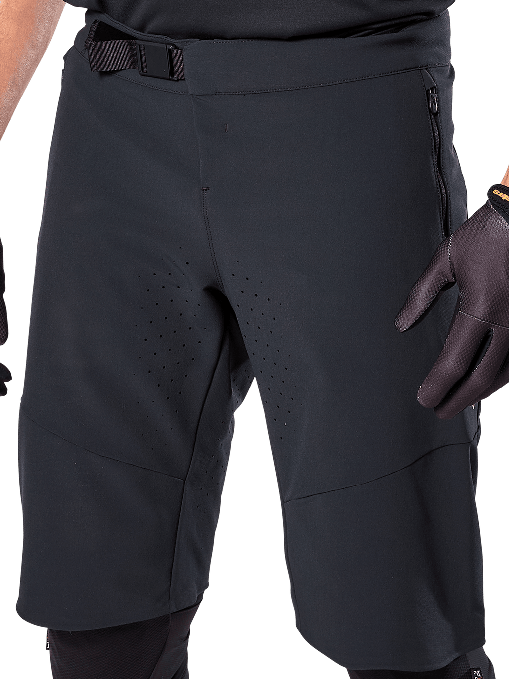 Alpinestars A-Aria Elite Shorts en color negro, vista en primer plano de la zona de la cintura y el muslo, con cierre de hebilla magnética, bolsillos con cremallera y perforaciones de ventilación cortadas con láser, usados con guantes de ciclismo negros para ciclismo de montaña.