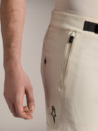 Alpinestars A-Aria Elite Shorts, shorts de ciclismo de montaña, color crudo, vista lateral de cerca con detalle de bolsillo con cremallera y cierre de hebilla magnética, prenda de alto rendimiento con detalles en negro