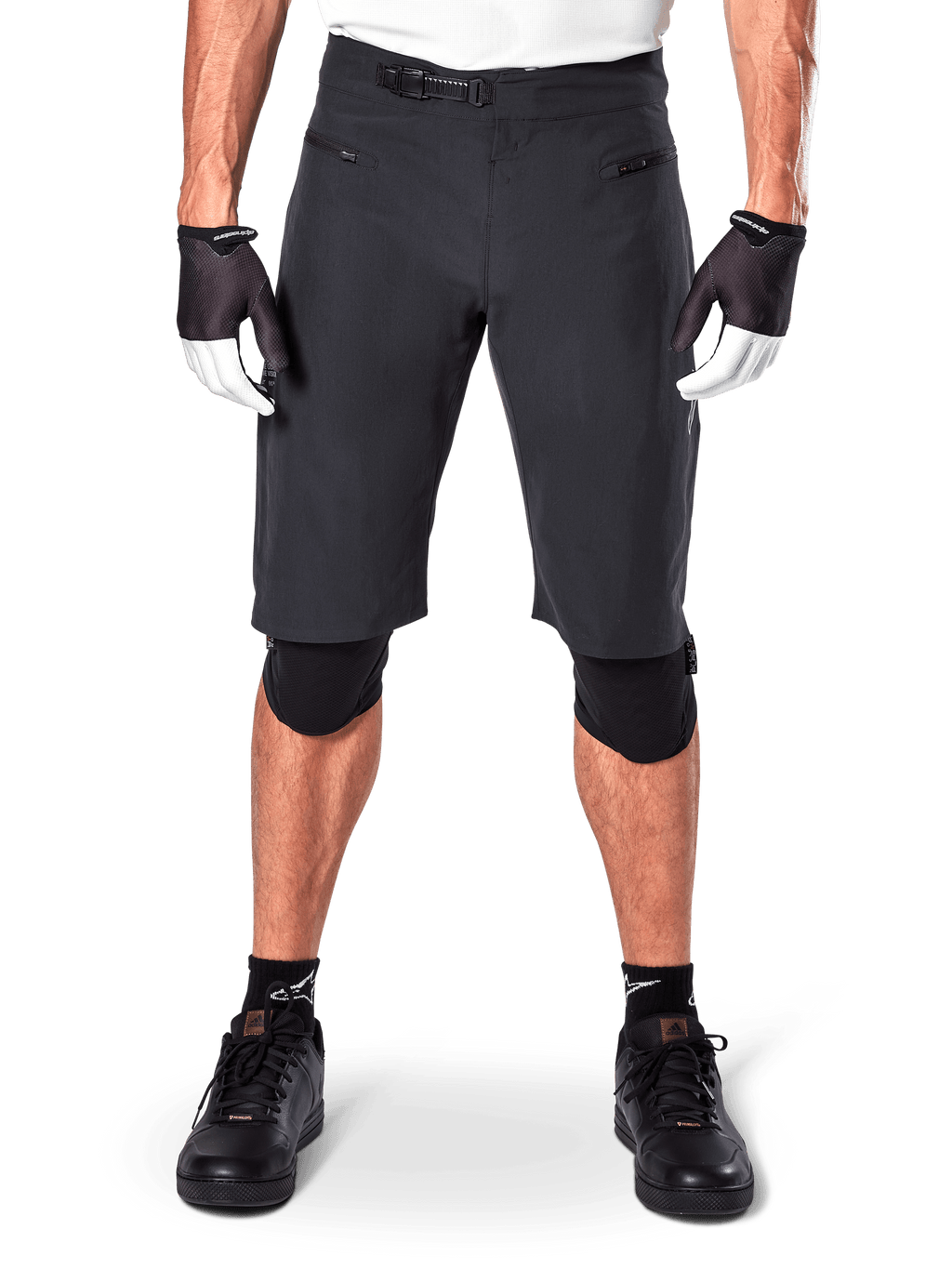 Shorts Alpinestars A-Aria, shorts de mountain bike negros, con cierre de trinquete en la cintura y bolsillos con cremallera, usados con guantes blancos y negros y rodilleras, equipamiento técnico de ciclismo para conducción todoterreno