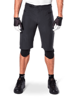 Shorts Alpinestars A-Aria, shorts de mountain bike negros, con cierre de trinquete en la cintura y bolsillos con cremallera, usados con guantes blancos y negros y rodilleras, equipamiento técnico de ciclismo para conducción todoterreno