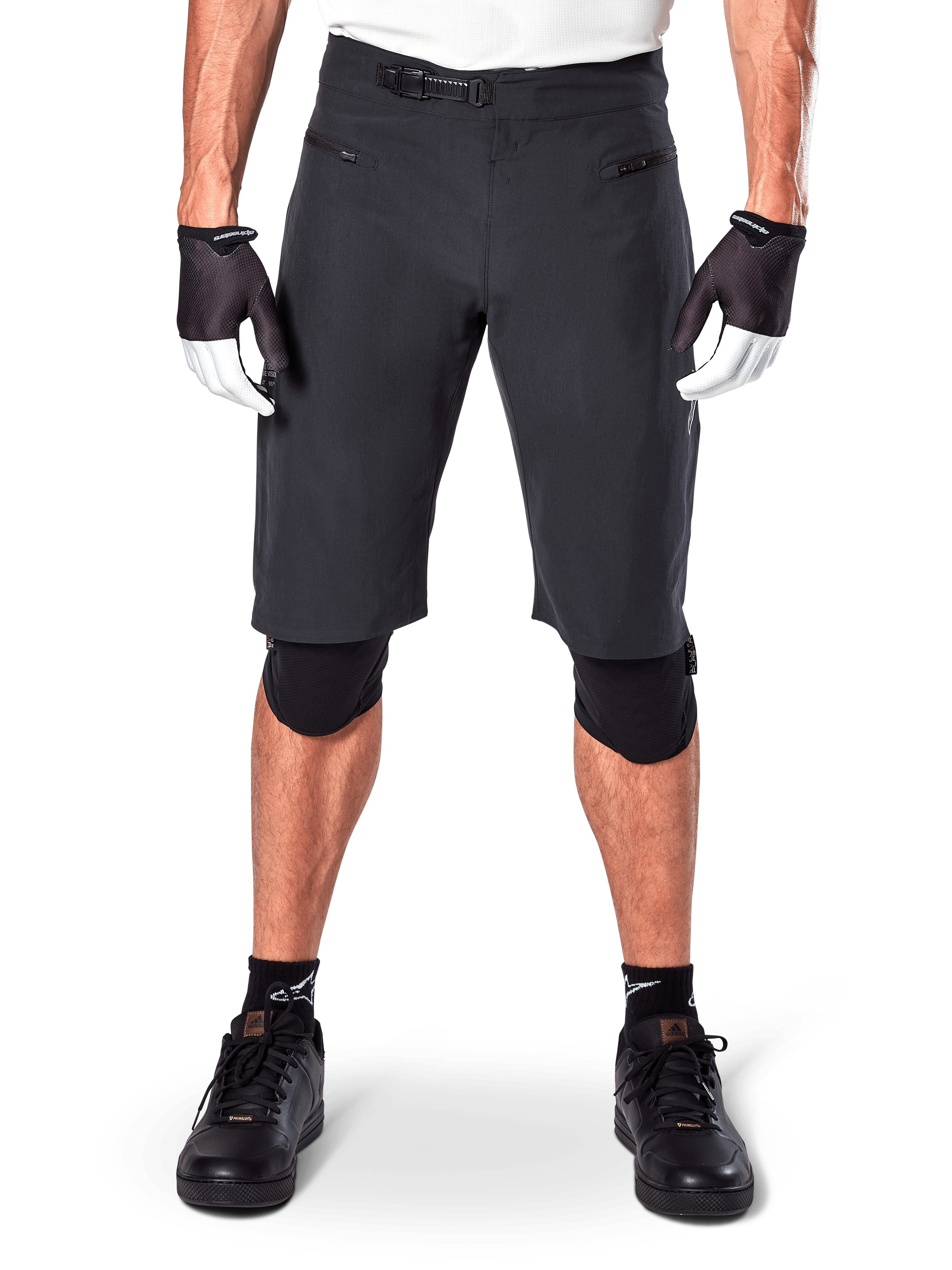 Shorts Alpinestars A-Aria, shorts de mountain bike negros, con cierre de trinquete en la cintura y bolsillos con cremallera, usados con guantes blancos y negros y rodilleras, equipamiento técnico de ciclismo para conducción todoterreno
