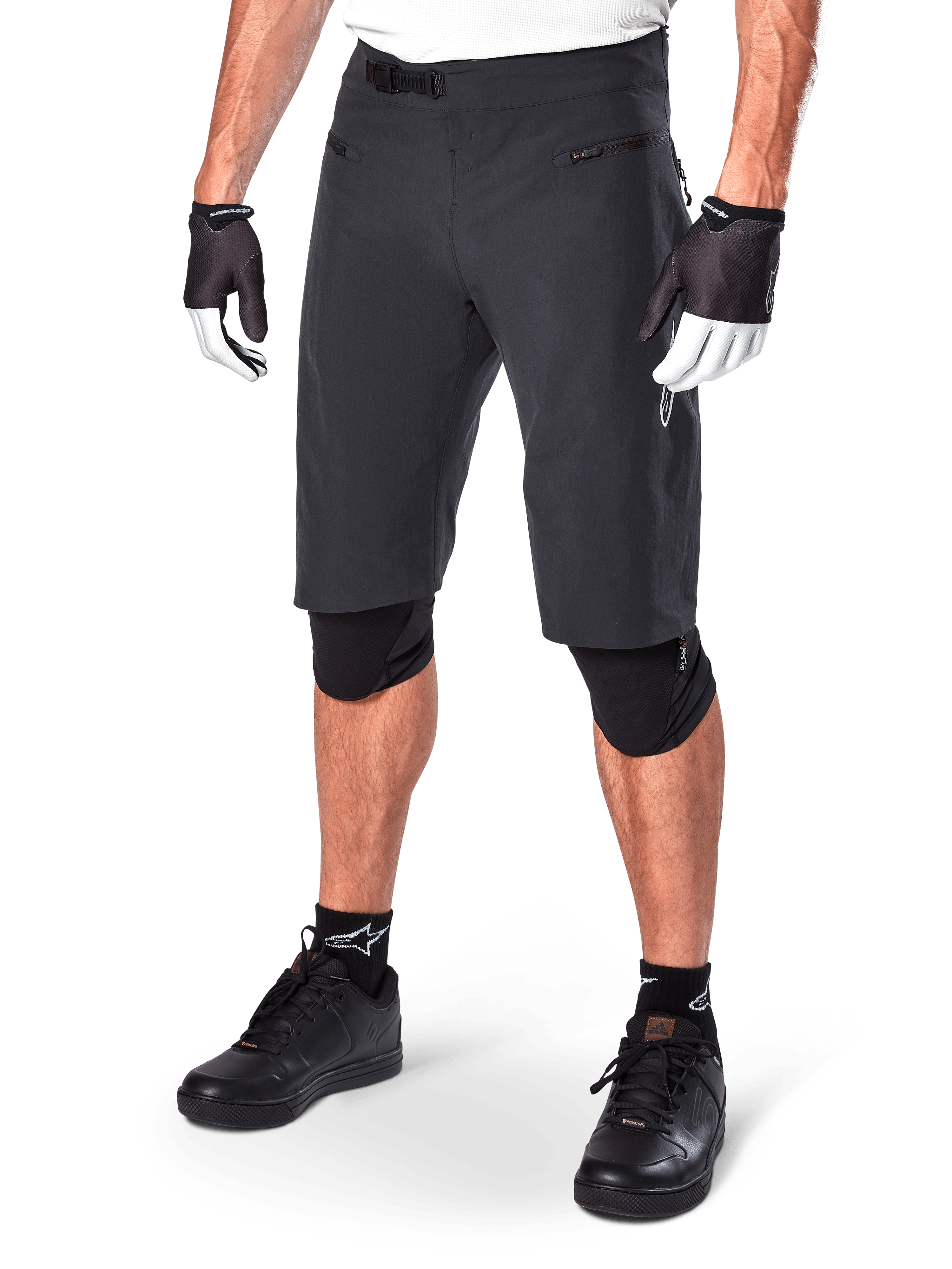 Alpinestars A-Aria Shorts, Mountain Biking Shorts, Black, knee-length with front zippered pockets and adjustable ratchet waist buckle, worn with black knee pads, socks, and cycling gloves